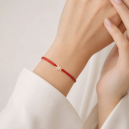 LuccheGold red thread bracelet with a small gold angel charm on a woman's wrist