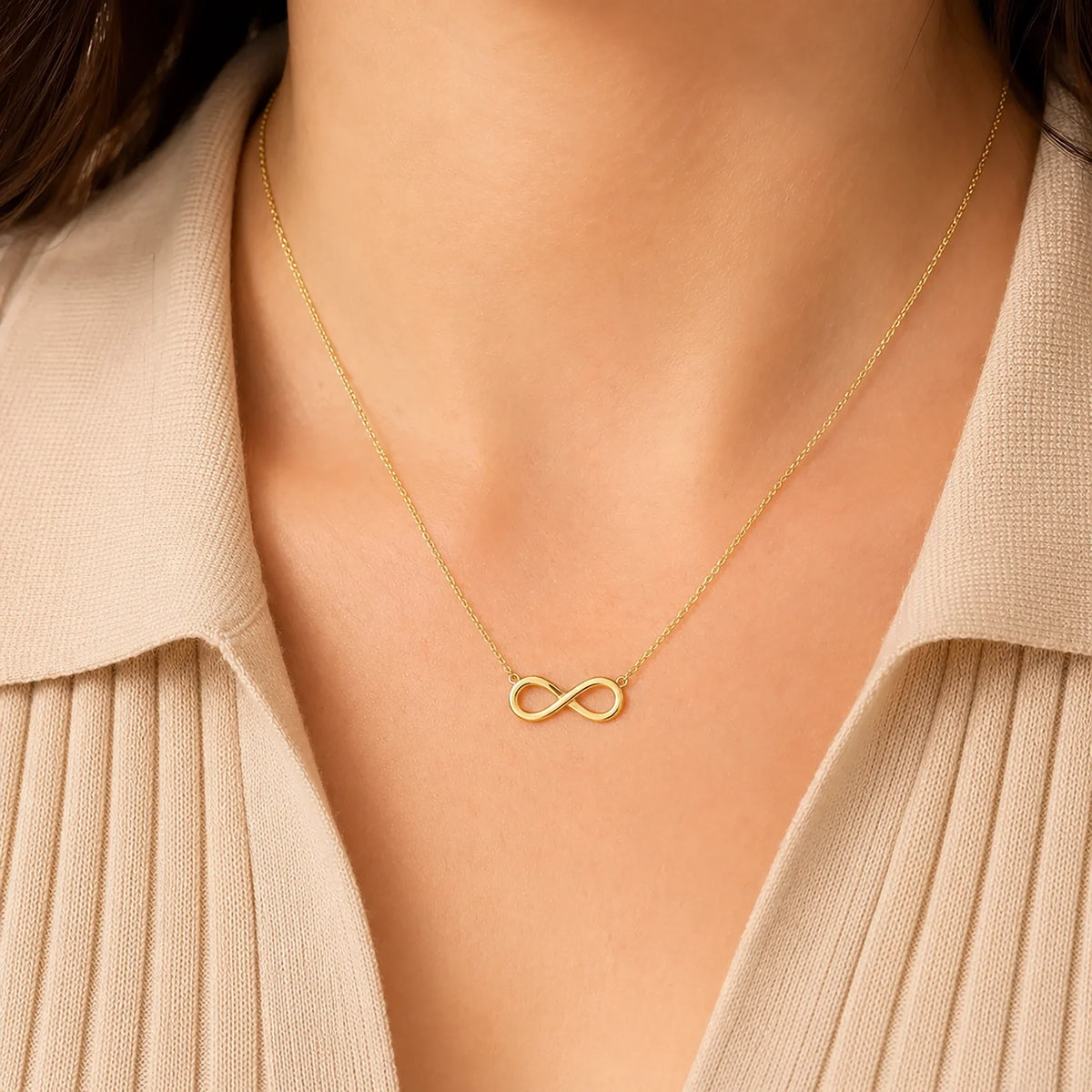 Woman wearing a Lucche 14K gold infinity symbol pendant necklace