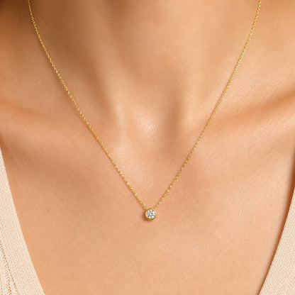 Woman wearing a delicate 14K gold necklace with a single cubic zirconia pendant by Lucche