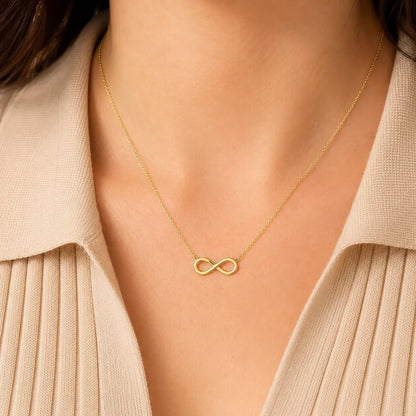 Woman wearing a Lucche 14K gold infinity symbol pendant necklace