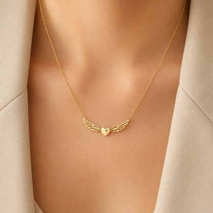 Lucche 14K gold necklace featuring a heart pendant with angel wings on a woman's neck